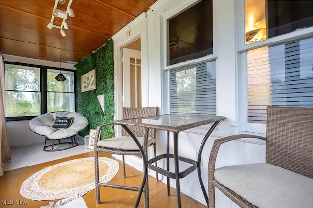 sunroom / solarium featuring wood finished floors and wood ceiling