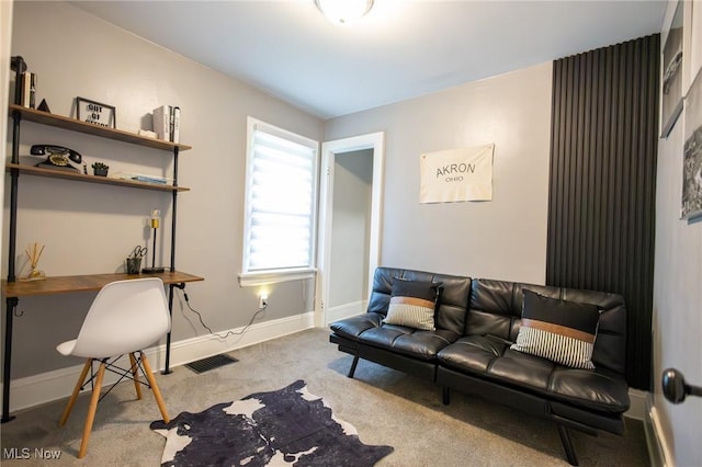 living area featuring carpet, a desk, and baseboards