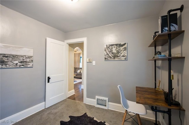 office area with carpet flooring, arched walkways, and baseboards