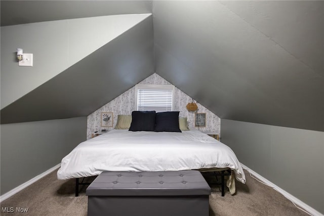 carpeted bedroom featuring lofted ceiling and baseboards