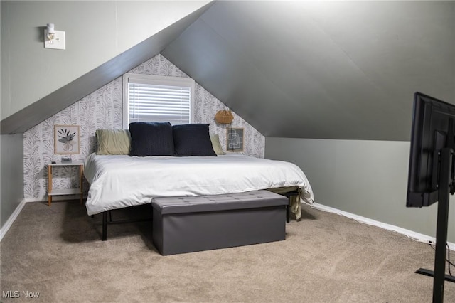 carpeted bedroom with vaulted ceiling and baseboards