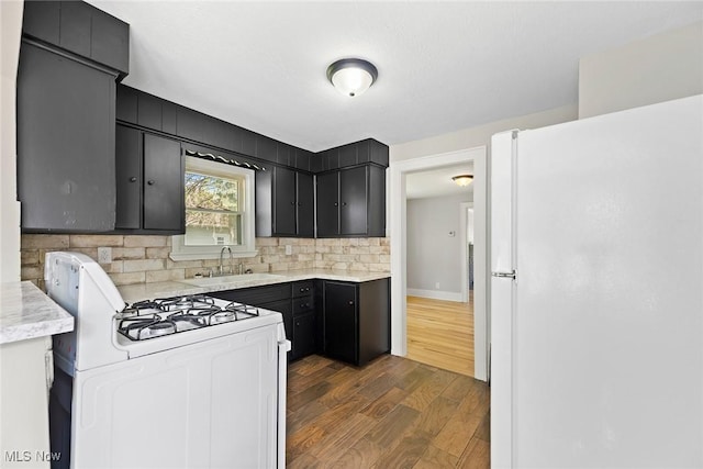 1254 Delos St, Akron, OH 44306 - kitchen with white appliances, a sink, dark cabinetry, dark wood-style flooring, and light countertops