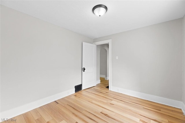 1254 Delos St, Akron, OH 44306 - empty room with light wood-style floors, baseboards, and arched walkways