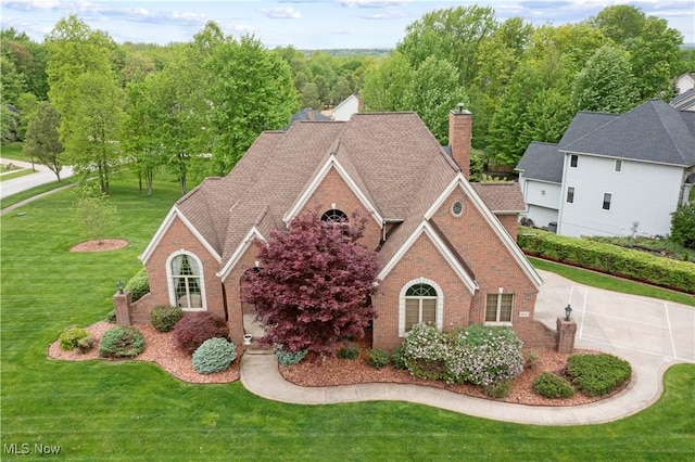 1042 Lancewood Dr, Macedonia, OH 44056 - view of front facade with brick siding, a front yard, and a chimney