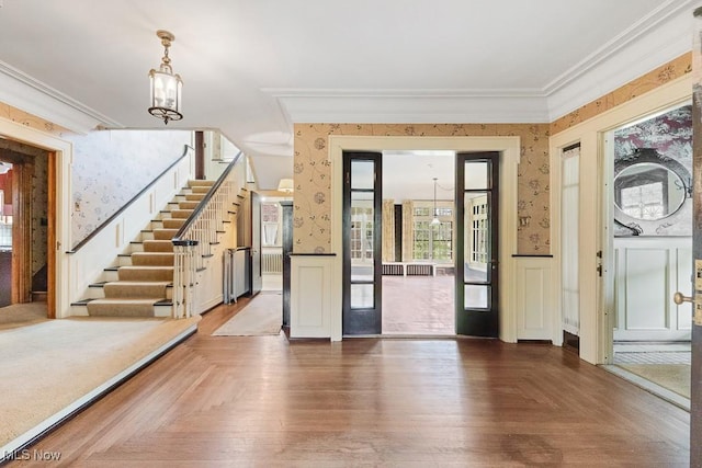 245 Merriman Rd, Akron, OH 44303 - entryway with wallpapered walls, wainscoting, crown molding, stairs, and a chandelier