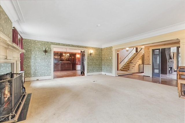 245 Merriman Rd, Akron, OH 44303 - unfurnished living room with stairway, crown molding, a high end fireplace, wallpapered walls, and carpet floors