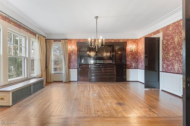 245 Merriman Rd, Akron, OH 44303 - unfurnished dining area featuring wallpapered walls, a chandelier, radiator heating unit, light wood-type flooring, and a wainscoted wall