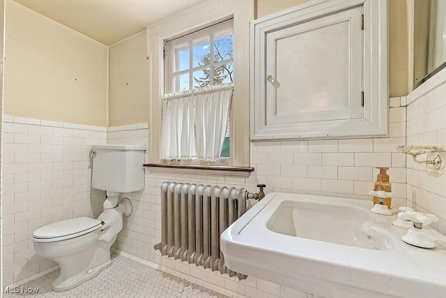 245 Merriman Rd, Akron, OH 44303 - half bathroom featuring tile walls, radiator, toilet, tile patterned flooring, and a wainscoted wall