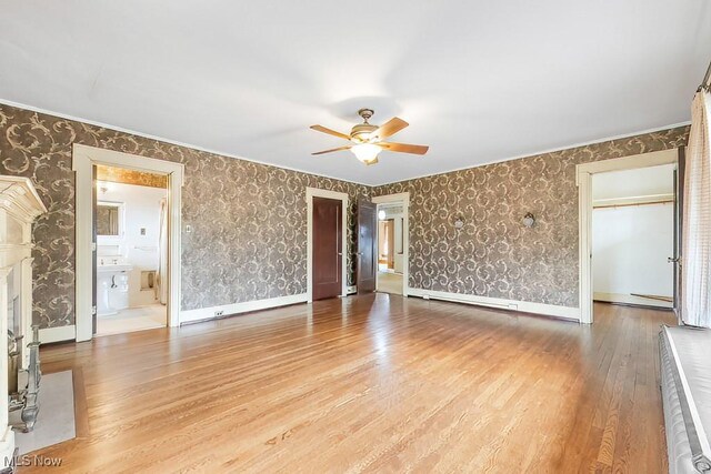 245 Merriman Rd, Akron, OH 44303 - unfurnished living room with a ceiling fan, wallpapered walls, wood finished floors, and baseboards