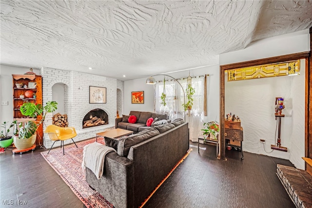 living area with dark wood-style floors and a brick fireplace