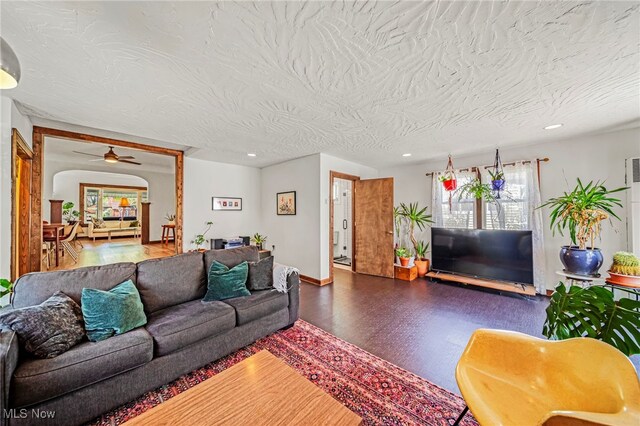 living room with a ceiling fan, baseboards, recessed lighting, and a textured ceiling