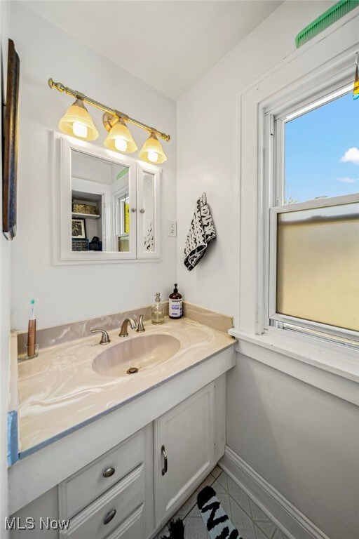 bathroom with tile patterned flooring, vanity, and baseboards