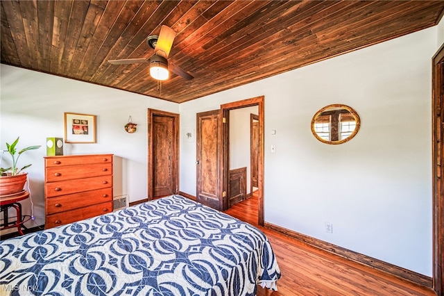 bedroom featuring wooden ceiling, baseboards, wood finished floors, and a ceiling fan