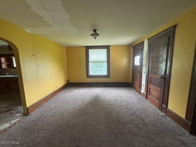 234 High Ave, Byesville, OH 43723 - spare room featuring arched walkways, carpet floors, and baseboards