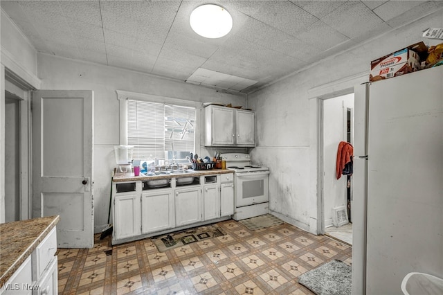 132 Irondale St, Elyria, OH 44035 - kitchen featuring white appliances, light floors, white cabinetry, and a sink