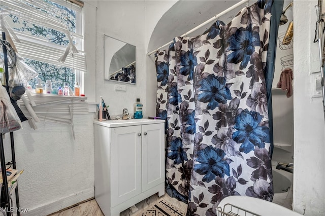 132 Irondale St, Elyria, OH 44035 - bathroom featuring vanity, a textured wall, baseboards, and shower / bathtub combination with curtain
