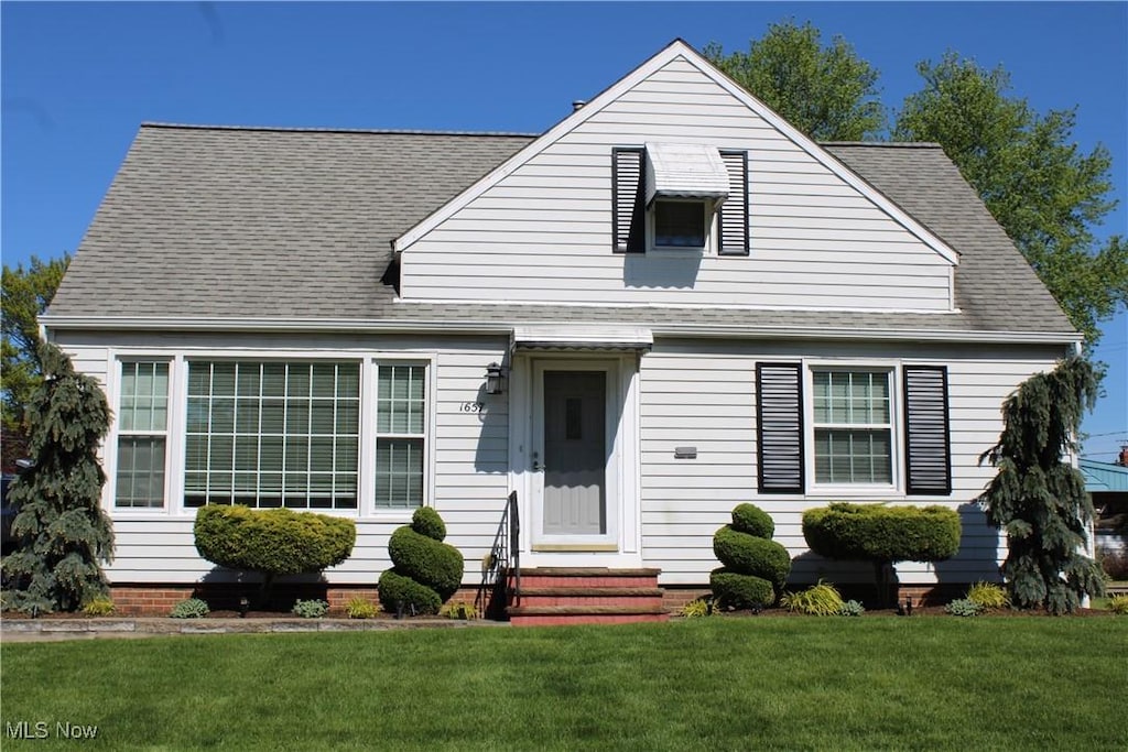 1657 Hawthorne Dr, Mayfield Heights, OH 44124 - view of front of home with entry steps, a front lawn, and roof with shingles