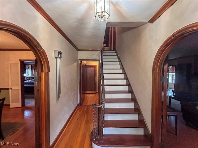 553 Willard Ave SE, Warren, OH 44483 - stairs with arched walkways, wood finished floors, and crown molding