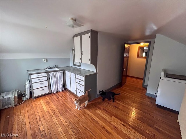 553 Willard Ave SE, Warren, OH 44483 - kitchen featuring light wood finished floors, vaulted ceiling, and white cabinetry