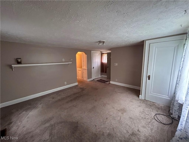 553 Willard Ave SE, Warren, OH 44483 - carpeted empty room featuring arched walkways and a textured ceiling