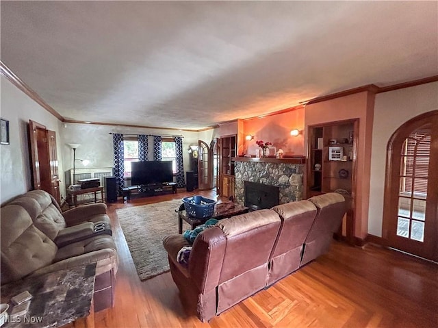 553 Willard Ave SE, Warren, OH 44483 - living room with crown molding, a fireplace, arched walkways, and wood finished floors
