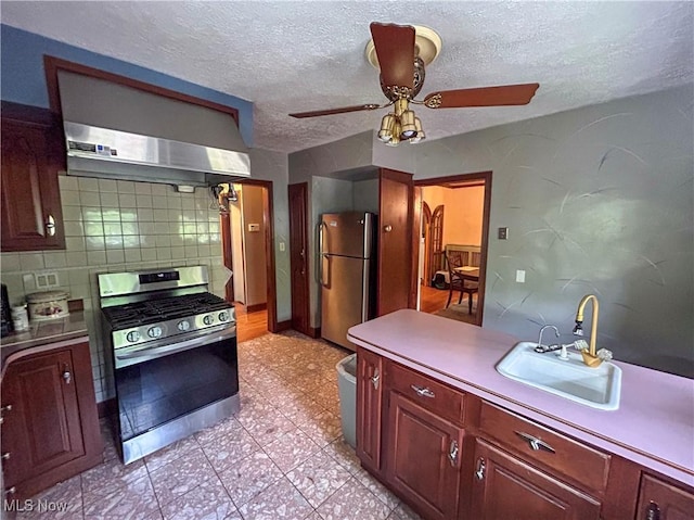 553 Willard Ave SE, Warren, OH 44483 - kitchen with stainless steel appliances, wall chimney exhaust hood, tasteful backsplash, a textured ceiling, and dark brown cabinets
