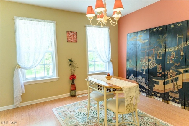 dining room with a chandelier, wood finished floors, and baseboards