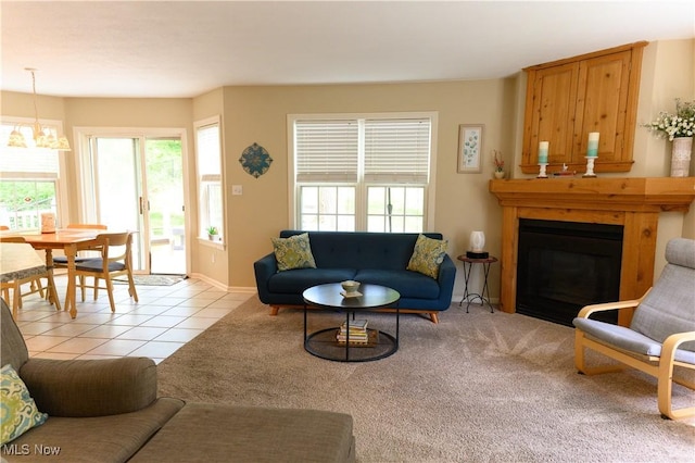 living area with a chandelier, plenty of natural light, a fireplace, and light tile patterned floors