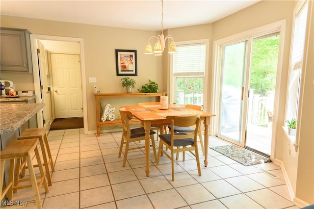 dining room with plenty of natural light, a chandelier, light tile patterned floors, and baseboards