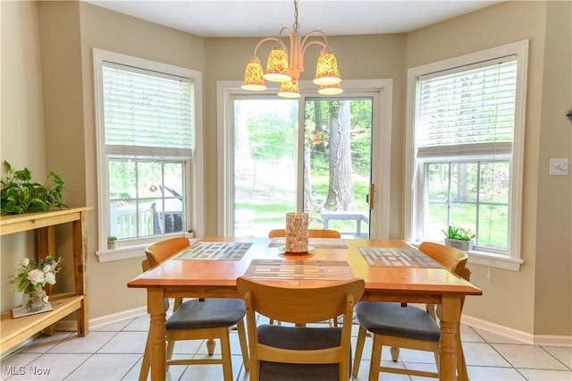 dining area featuring light tile patterned floors, healthy amount of natural light, and a chandelier