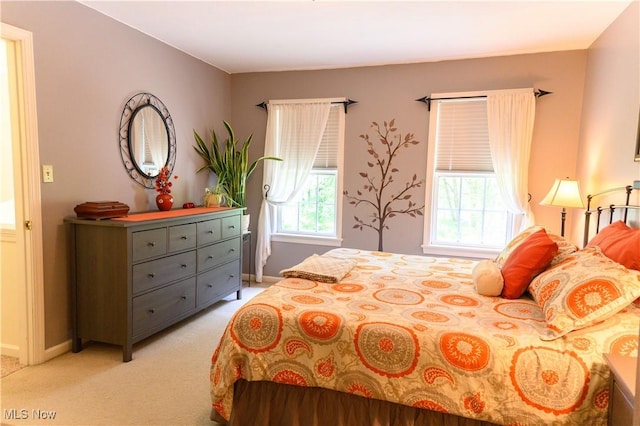 bedroom with light colored carpet and baseboards