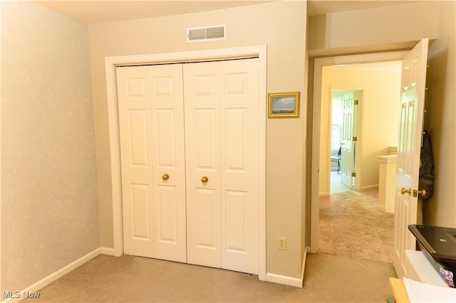 bedroom with light colored carpet, a closet, and baseboards