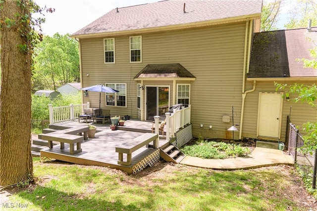 rear view of house featuring a deck and a shingled roof