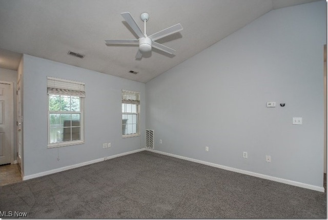 unfurnished room with vaulted ceiling, ceiling fan, dark carpet, and baseboards