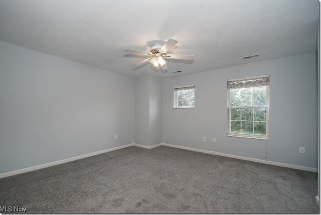 carpeted empty room with a ceiling fan and baseboards