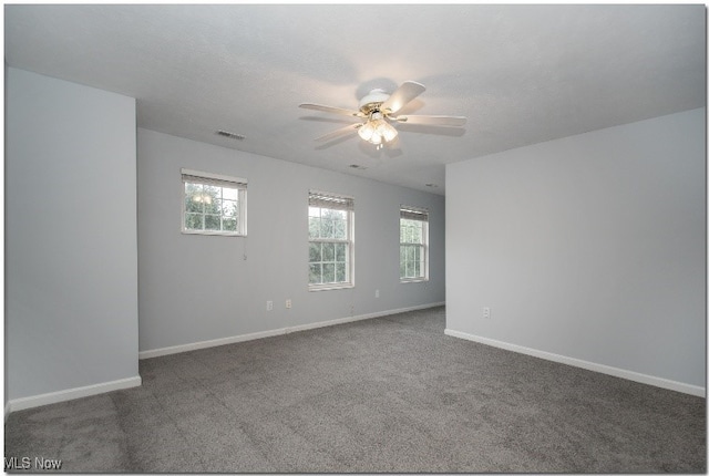 carpeted empty room with a ceiling fan and baseboards