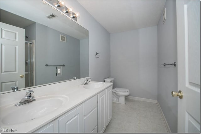 bathroom with toilet, double vanity, baseboards, an enclosed shower, and tile patterned floors