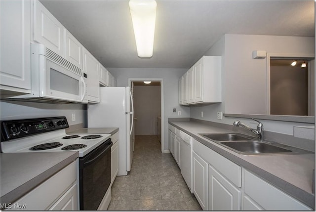 kitchen featuring white appliances, a sink, white cabinets, and light countertops