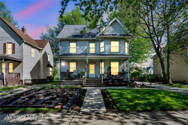 1821 E 30th St, Lorain, OH 44055 - view of front facade featuring covered porch and a front lawn