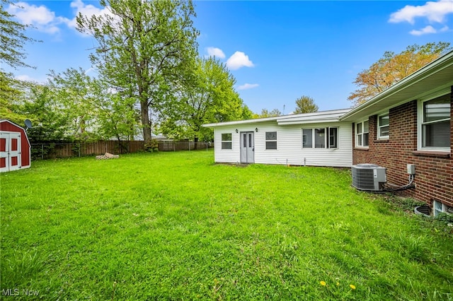 view of yard with central AC, a storage shed, and an outdoor structure
