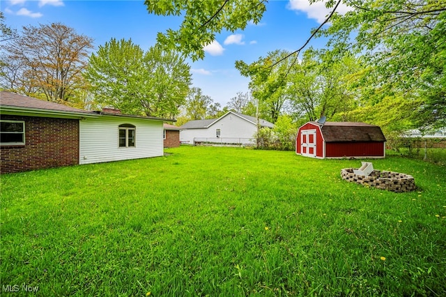 view of yard featuring a shed, an outbuilding, and an outdoor fire pit