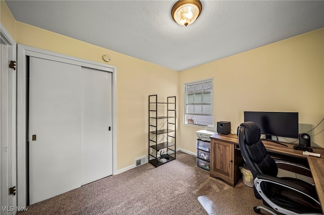 office space with dark colored carpet, baseboards, and a textured ceiling