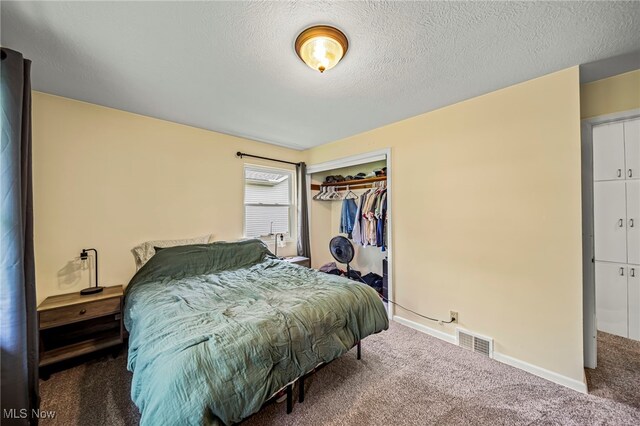 carpeted bedroom with a closet, a textured ceiling, and baseboards