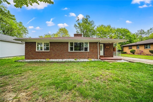 ranch-style home featuring brick siding, a chimney, a front yard, and covered porch