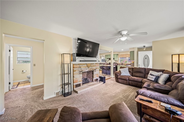 carpeted living area featuring ceiling fan, plenty of natural light, and baseboards