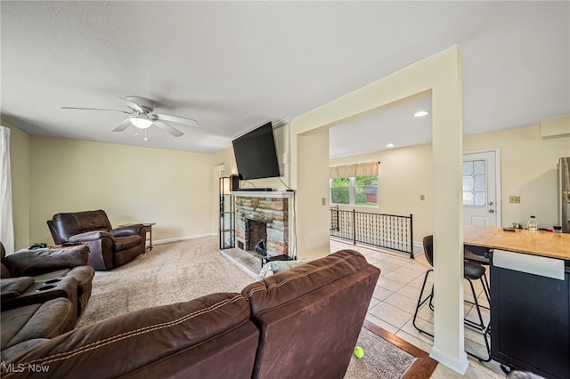 living area featuring a ceiling fan, a fireplace, baseboards, recessed lighting, and light tile patterned flooring