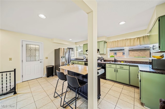 kitchen featuring green cabinetry, dishwasher, stainless steel fridge with ice dispenser, a sink, and recessed lighting