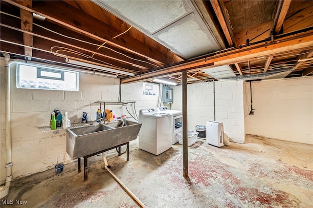 below grade area with washer and clothes dryer, a sink, and electric panel