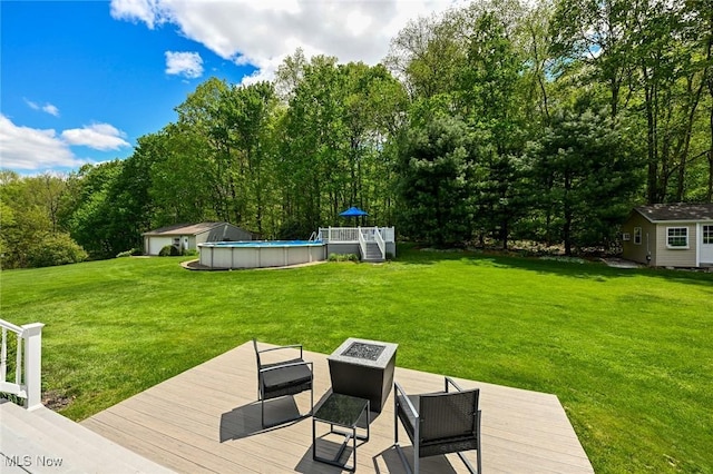 1152 Terraho Dr, Salem, OH 44460 - view of green lawn with a deck, an outdoor pool, a fire pit, and an outbuilding