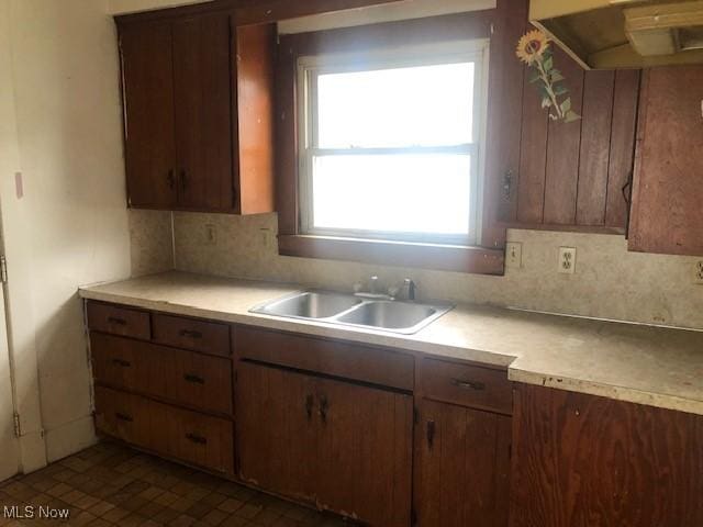 2117 Maple Ave NE, Canton, OH 44714 - kitchen with under cabinet range hood, a sink, light countertops, and backsplash